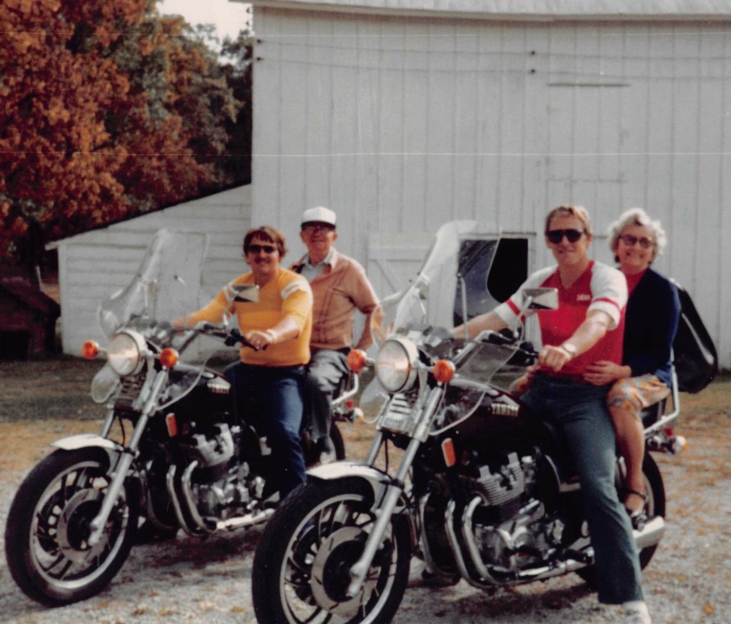 Sam and John on bikes at Walter and Martha Sitto's farm. Uncle Walter is on Sam's bike, and Aunt Martha is on John's bike.